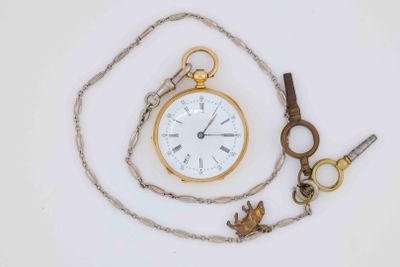 a gold pocket watch and a chain with a bird on it
