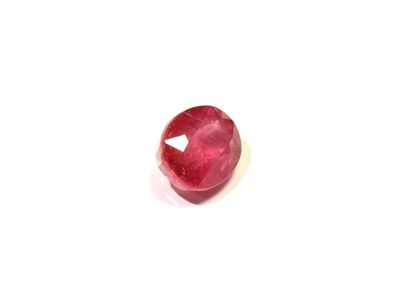 gros plan d'une pierre de rubis rouge sur une surface blanche