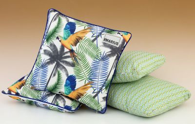 a close up of three pillows with parrots on them