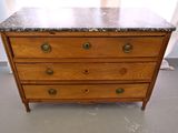 a wooden chest of drawers with a marble top
