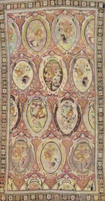 an antique rug with many faces on a pink background