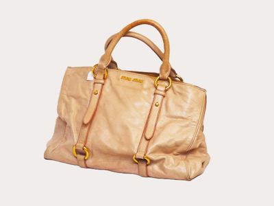 beige leather handbag on a white background with a white background