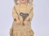 a doll that is holding a pair of scissors in it ' s hands