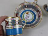 a person holding a cup and saucer in their hand
