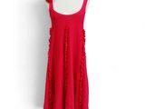 a red dress with ruffles on it on a mannequin stand