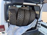 tires in the back of a truck with a tarp in the trunk
