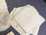 a pile of folded cloths on a table next to a pen