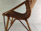 a wicker chair that is sitting on a white surface
