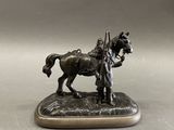 statue en bronze représentant un homme à cheval tenant un bâton