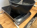 a person that is cooking on a stove with a whisk