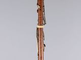 a wooden bassoon on a stand with a chain around it