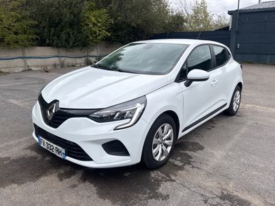 une voiture blanche garée dans un parking à côté d'un bâtiment