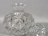 a clear glass bottle with a glass stopper next to it