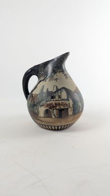 a black and white vase with a picture of a farm scene on it