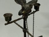 a statue of a bird with a pipe on a stand