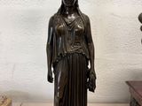 bronze statue of a woman with a bird on her head