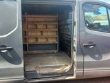 a grey van with a wooden bench in the back