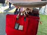 someone is holding a red bag with a tag on it