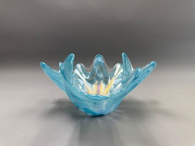 un bol en verre bleu avec un centre jaune posé sur une table