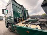 a green truck that is parked in a lot