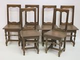 four chairs are lined up in a row on a white surface