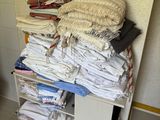 une pile de vêtements pliés posée sur une étagère dans une pièce