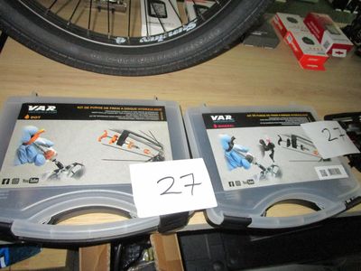 deux boîtes à outils posées sur une table à côté d'un pneu de vélo