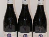 trois bouteilles de vin posées sur une table l'une à côté de l'autre