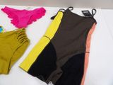 two swimsuits are laying on a bed next to each other