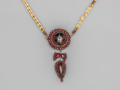 un collier en or et grenat avec un pendentif en pierre rouge