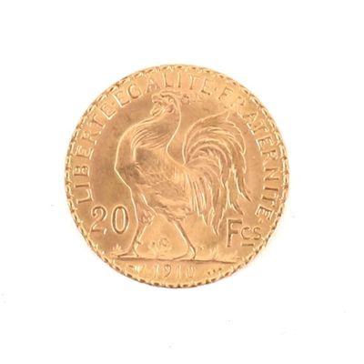 une pièce d'or représentant un coq sur un fond blanc