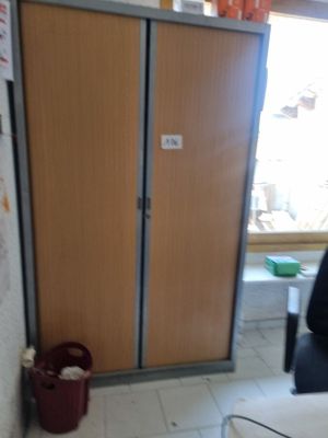 a room with a door and a trash can in it