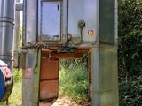 un grand réservoir métallique au milieu d'un champ