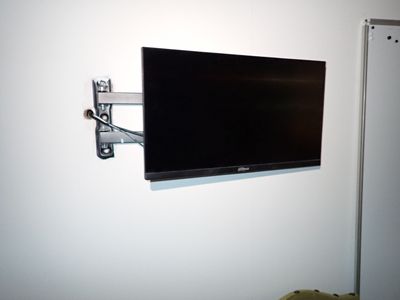 un téléviseur à écran plat fixé au mur d'une pièce