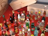 many bottles of liquor on a table with a red table cloth