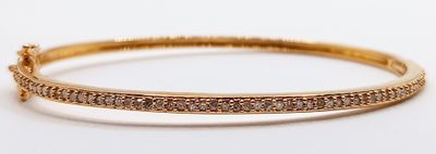 a close up of a gold bracelet with diamonds on it