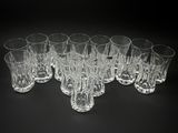 six verres transparents sont alignés sur une surface noire