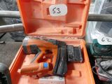 une boîte à outils orange contenant un marteau et une cloueuse