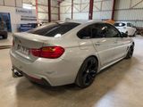 the rear end of a white bmw car parked in a garage