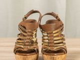 an image of a pair of women ' s sandals on a wooden table