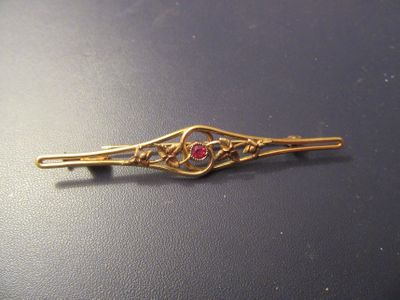 une image représentant une barrette dorée ornée de pierres rouges