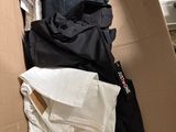 une boîte en carton remplie de vêtements et d'une paire de chaussures