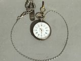 a pocket watch with a chain around it on a table