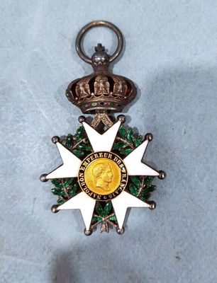 a silver and gold medal with a crown on it