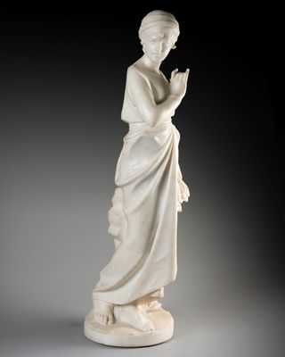 une statue en marbre blanc représentant une femme les mains jointes