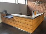 a wooden counter in a room with a brick wall behind it