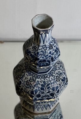 a blue and white vase sitting on top of a stack of books