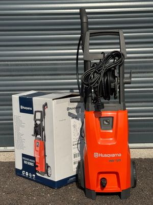 une pompe électrique orange posée à côté d'une boîte posée par terre