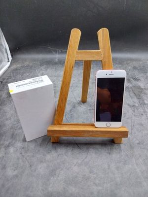 un chevalet en bois sur lequel est posé un téléphone portable, à côté d'une boîte