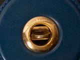 a close up of a blue purse with a gold buckle